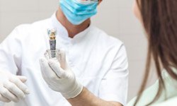 Dentist showing patient implant model
