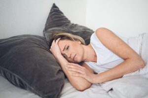 Exhausted woman lying in bed after night of poor sleep